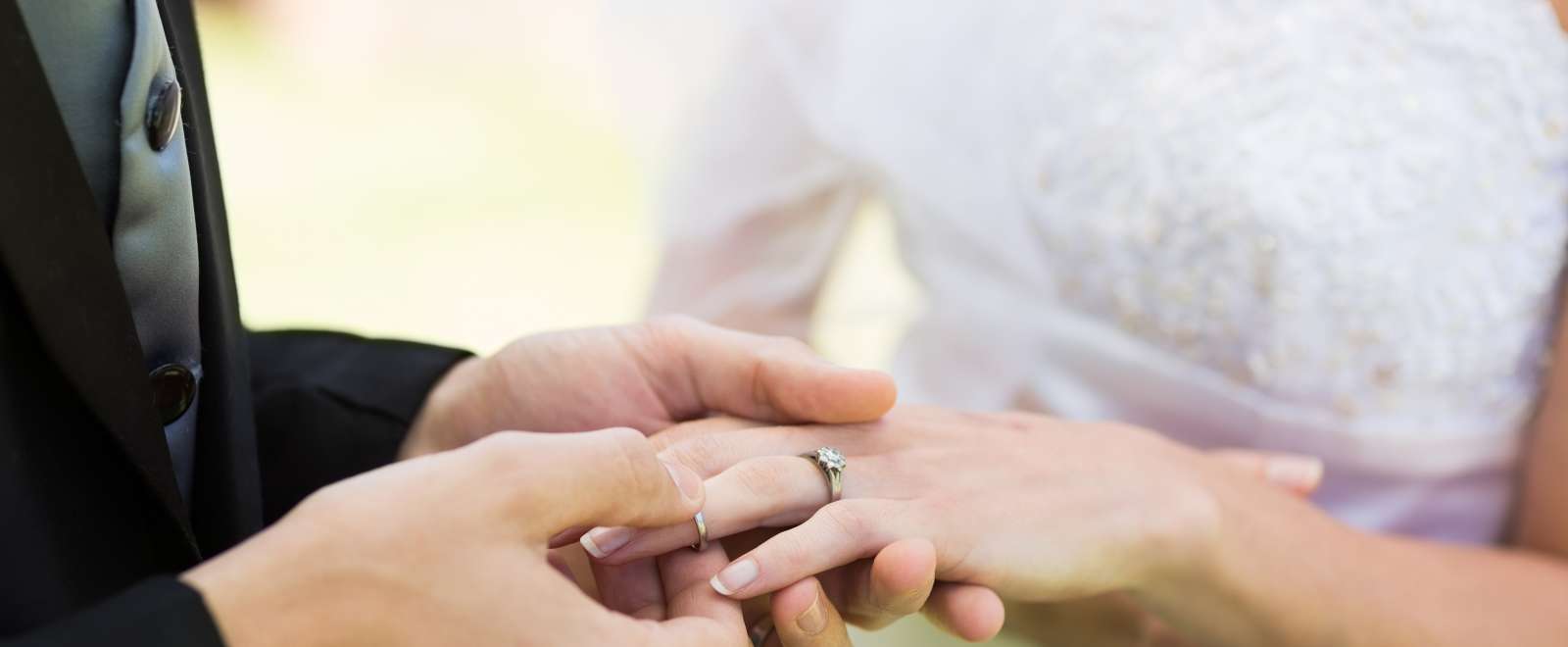Groom putting wedding ring on the Brides finger