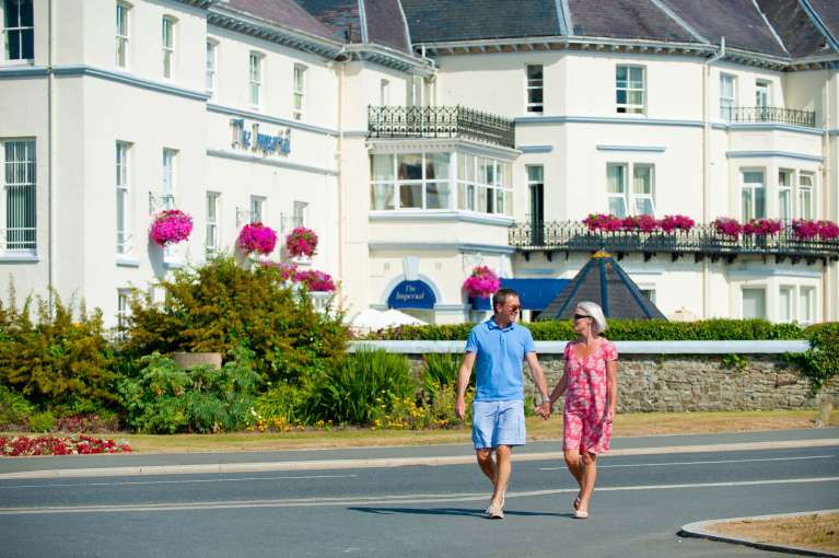 Imperial Hotel Couple Crossing Over Road in Front of Hotel